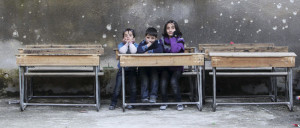 Children sit on school benches at Al-Tawheed school in Aleppo