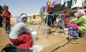 Syrian refugees wash clothes at Al Zaatri refugee camp in the Jordanian city of Mafraq