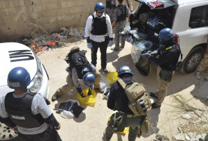 U.N. chemical weapons experts prepare before collecting samples from one of the sites of an alleged chemical weapons attack in Zamalka